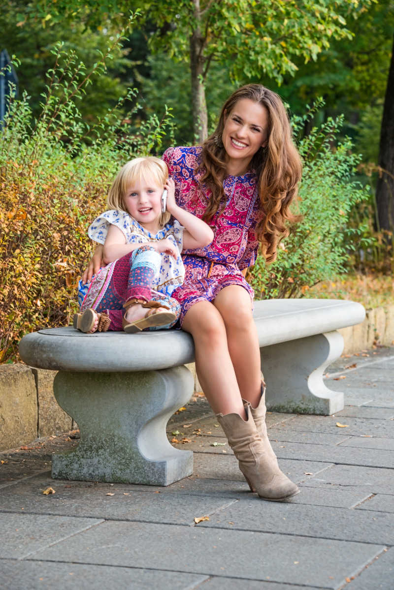 在公园的长凳上休息的快乐母女