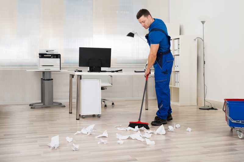 男子用扫帚打扫地板