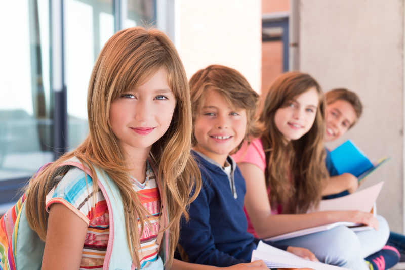 坐在台阶上四个微笑的学生