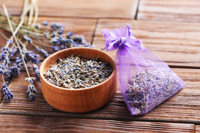 木纹理桌面上的薰衣草花束袋装薰衣草花和一碗薰衣草花朵