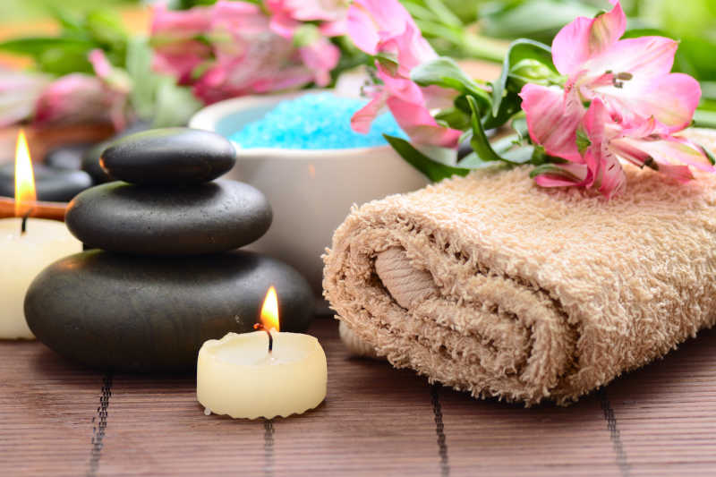 棕色竹帘上的毛巾和香薰蜡烛