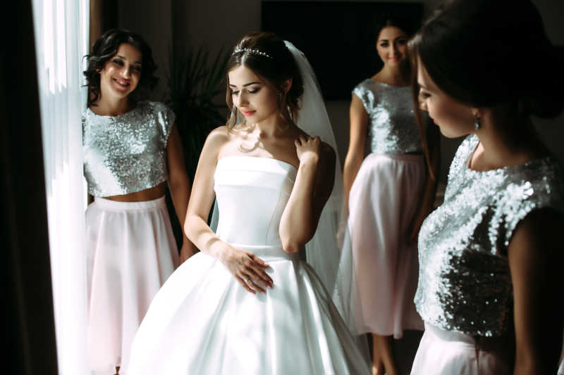 美丽的年轻新娘和高兴的伴娘团