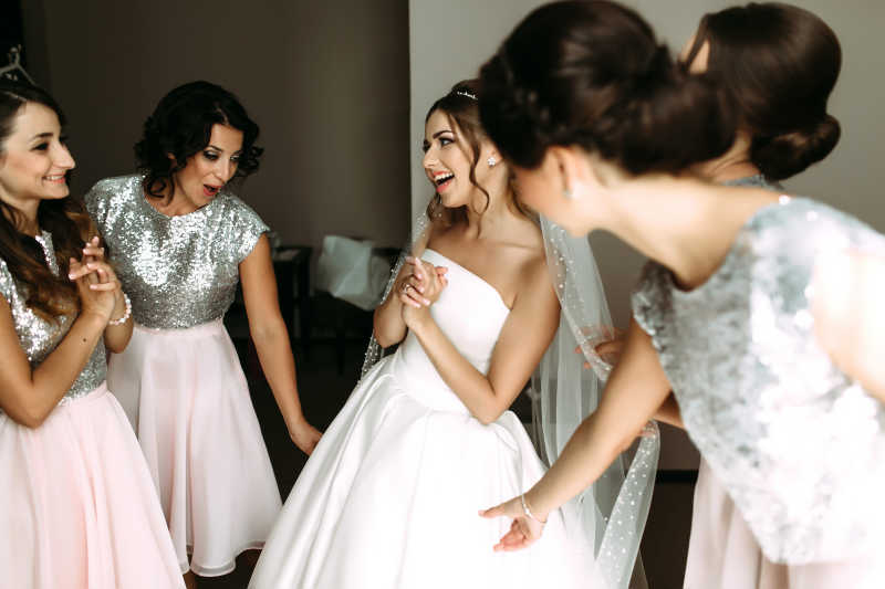 伴娘一起欣赏新娘的婚纱