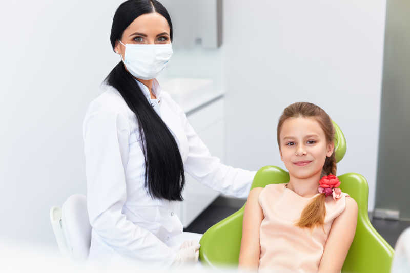 小女孩在牙科椅子上接受牙医的治疗