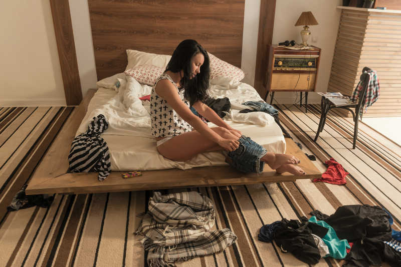 美女正在房间穿短裤