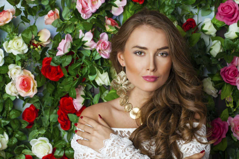 各种鲜花花墙前面的年轻美女