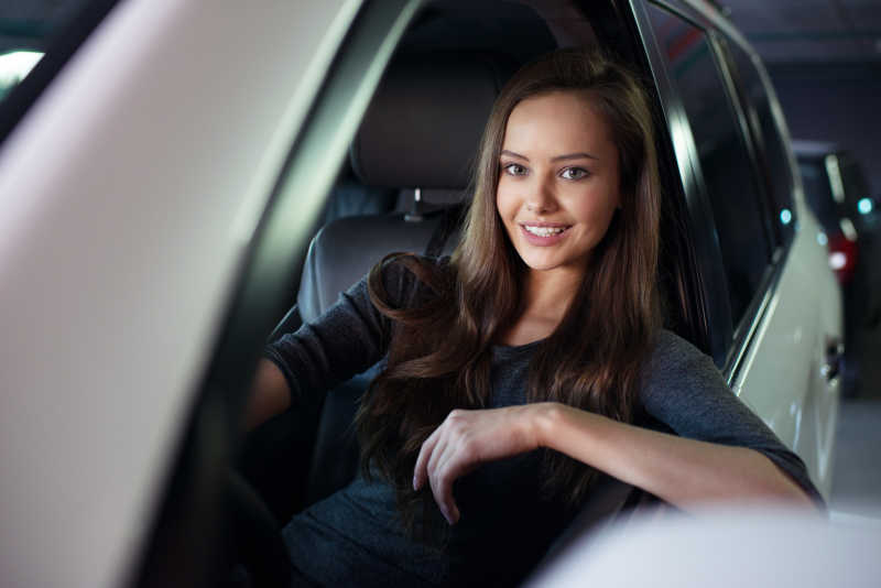 坐在车里开心微笑的美女