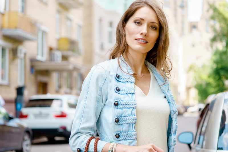 户外提着包的时尚美女