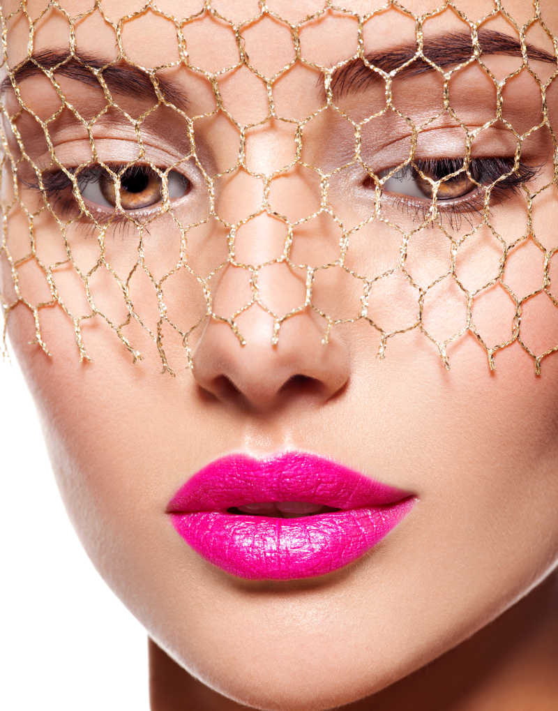 美女画着精致妆容戴着金色面纱