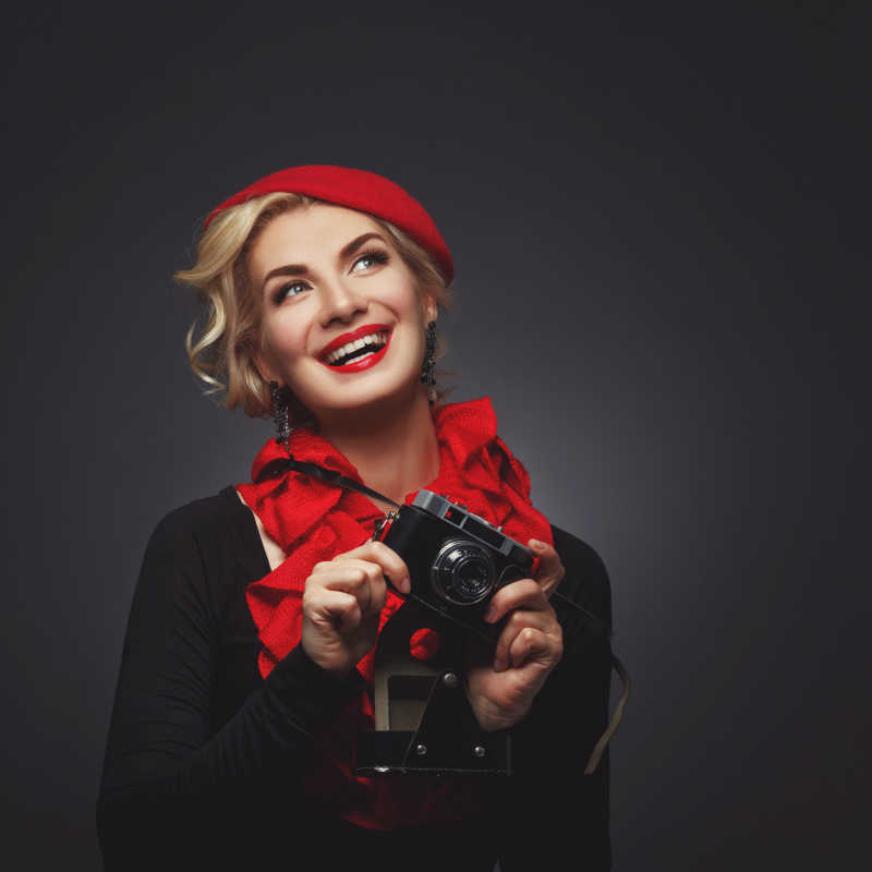 美女戴着贝雷帽拿着复古相机