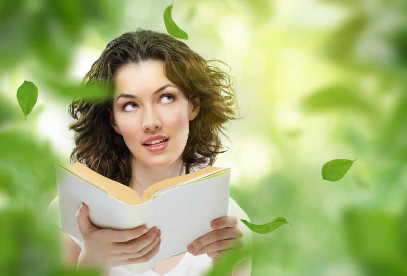大自然背景上看书的美丽女人