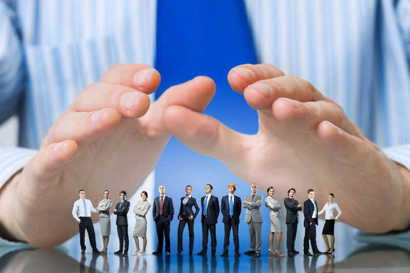 青年用手保护迷你商人团队