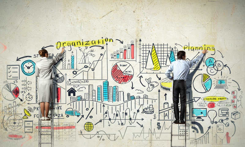 在墙上涂鸦的两个商人