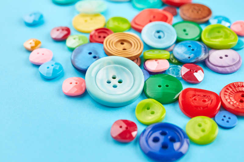 放在蓝色背景上的彩色纽扣