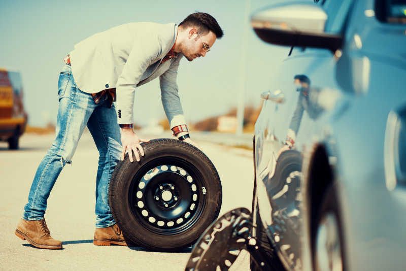 换轮胎的年轻司机