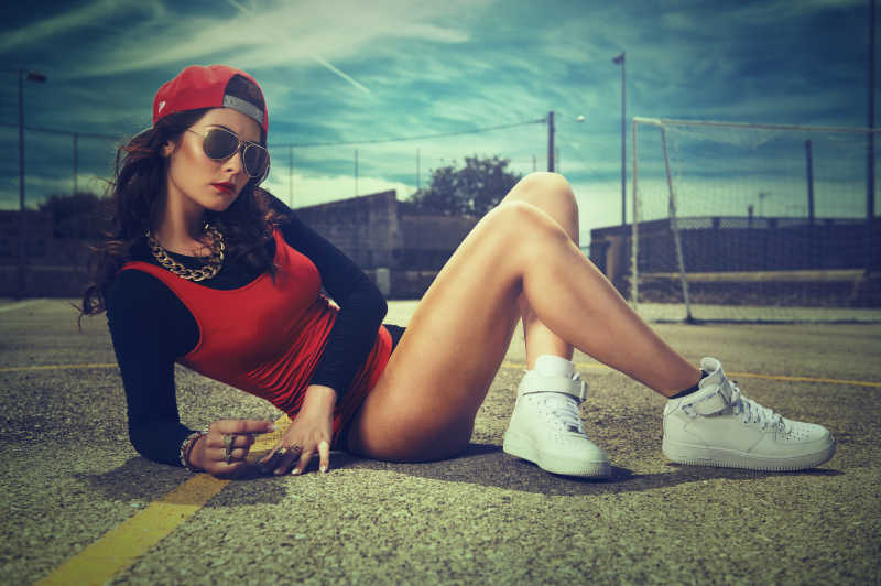 坐在地上的戴墨镜的酷帅街头女孩