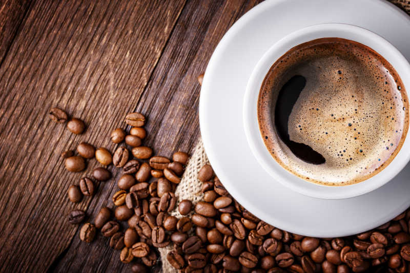 木几上的咖啡杯与咖啡豆