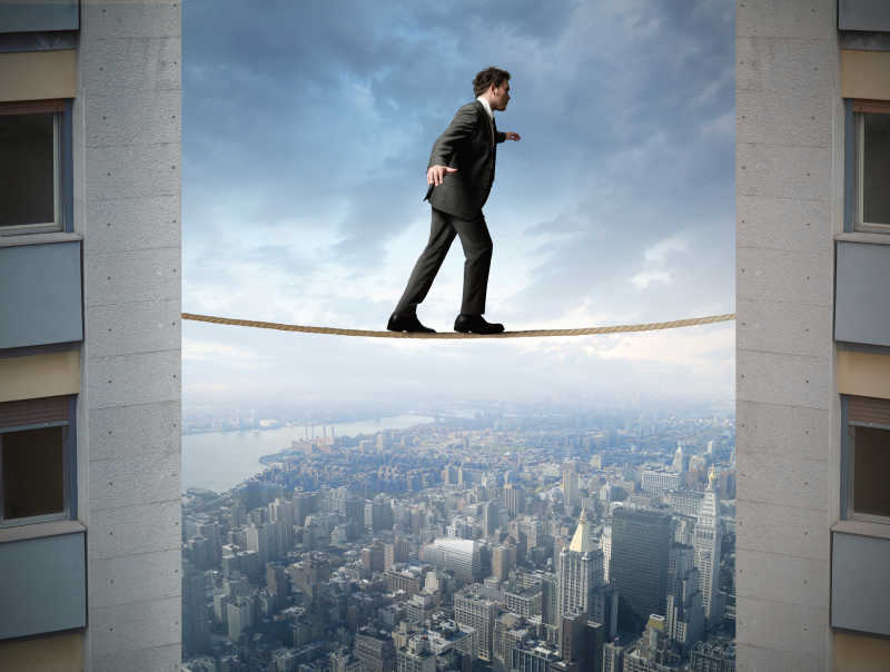 行走在城市高空中绳索上的男子