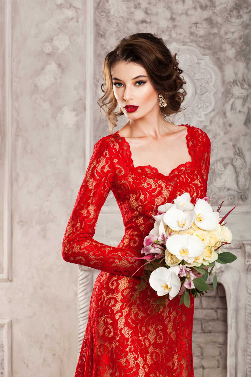 漂亮的穿红色蕾丝长裙的年轻女人