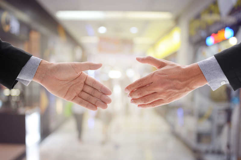 百货商店背景前的握手