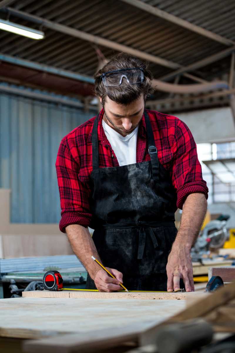 木工专心的在木板上画图