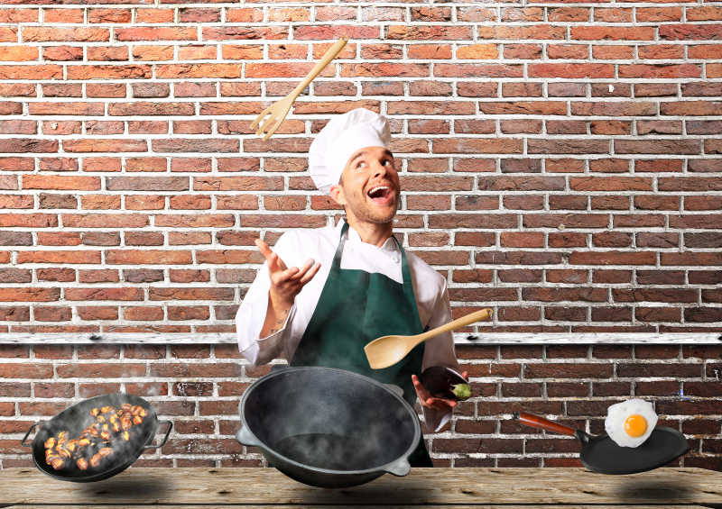 欢快的厨师在厨房里烹饪蔬菜和其他食物