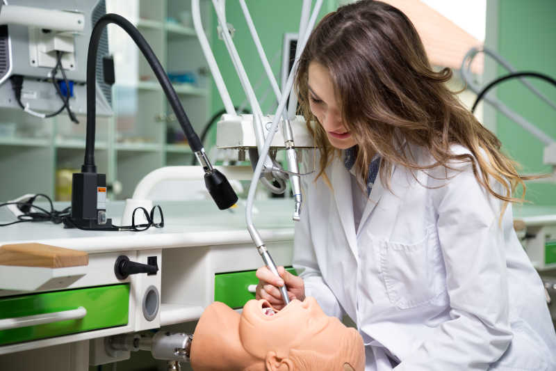 在诊所认真练习的女性牙科医生