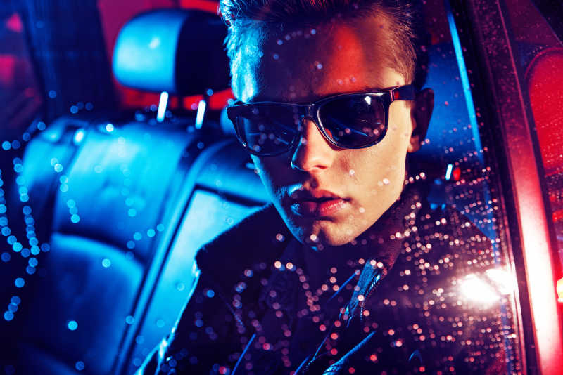 夜晚坐在车里的年轻人