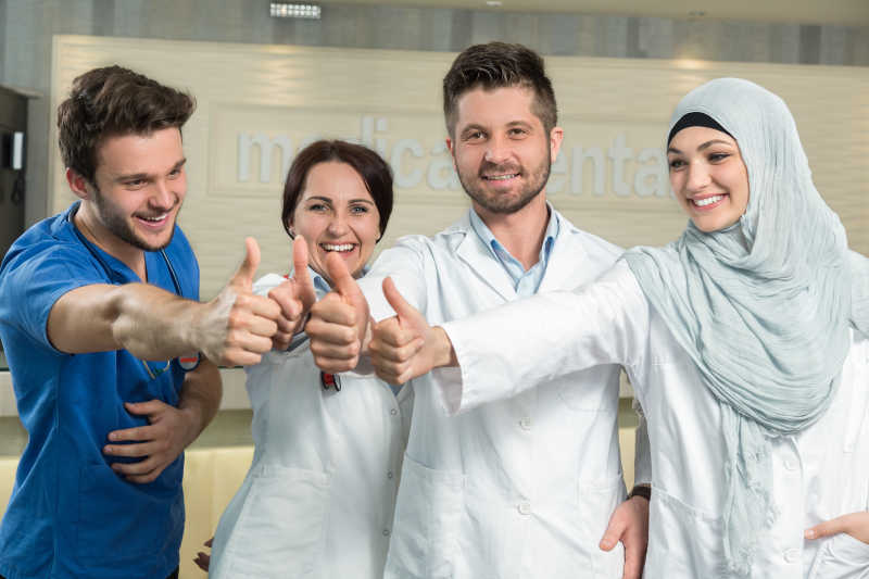 医院里微笑互相鼓励的年轻医生团队