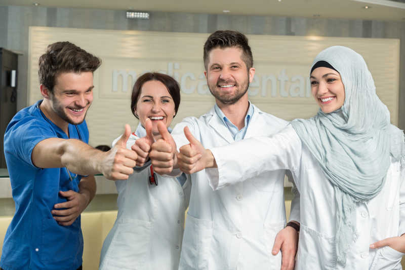 年轻快乐的竖起拇指的医生团队