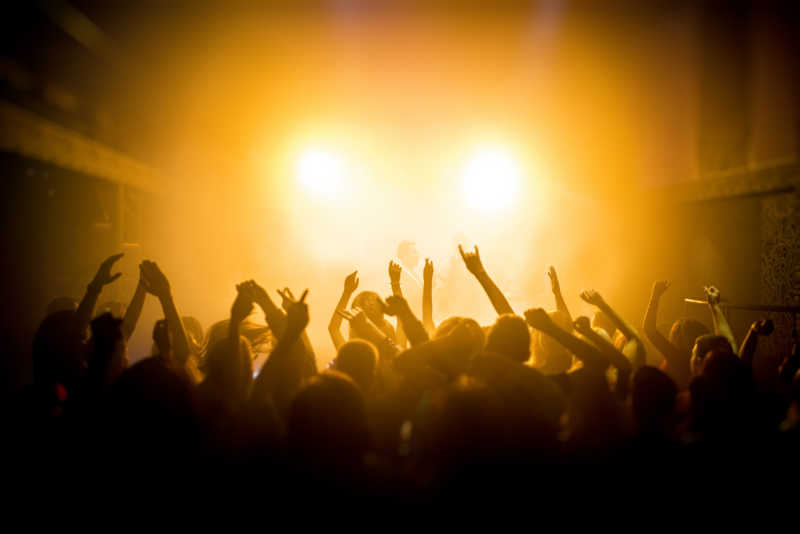 人们举手欣赏夜总会音乐会