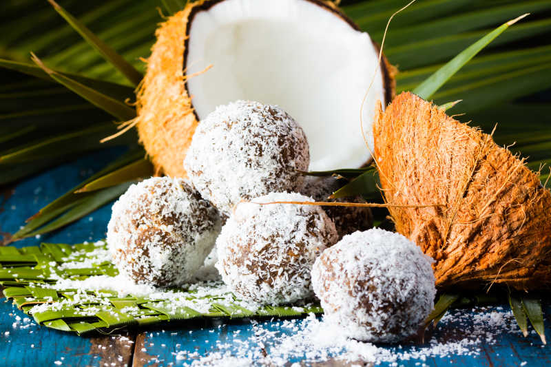 绿色垫子上的打开的椰肉和椰球