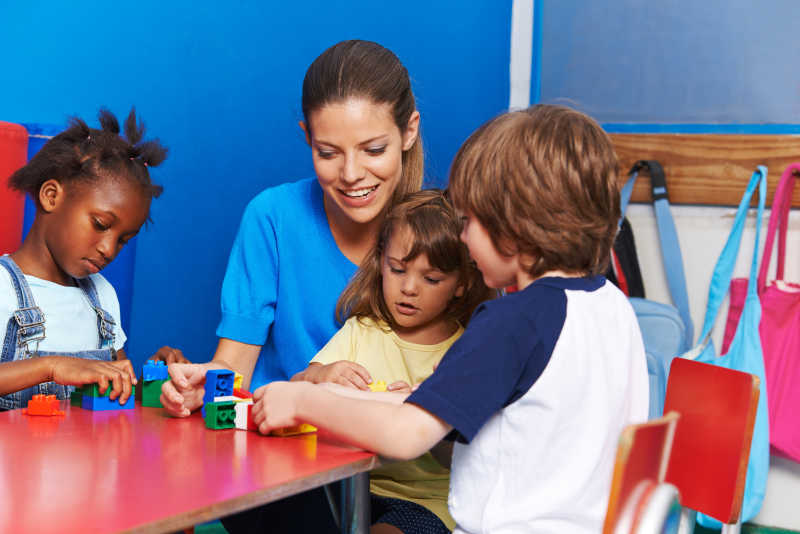 老师带着孩子做积木游戏