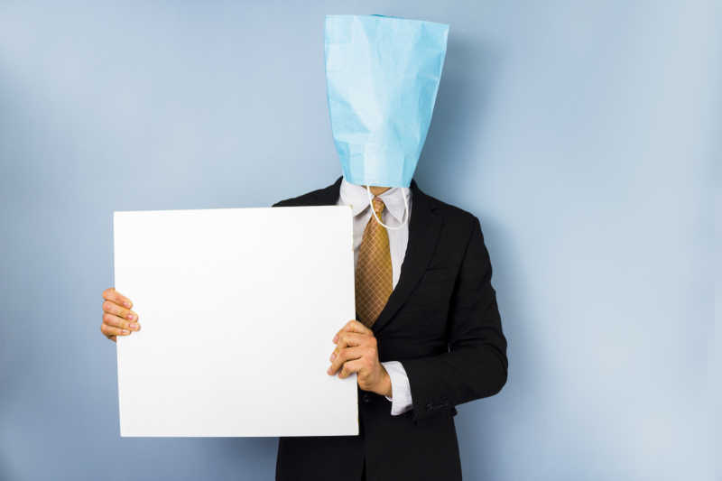 拿着空白广告牌头上戴着蓝色塑料袋的商人