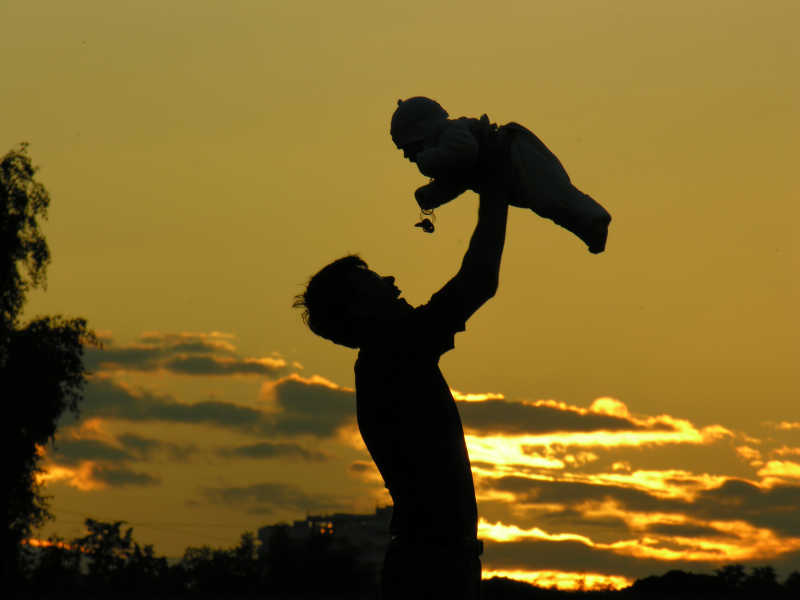 夕阳下父亲抱着孩子