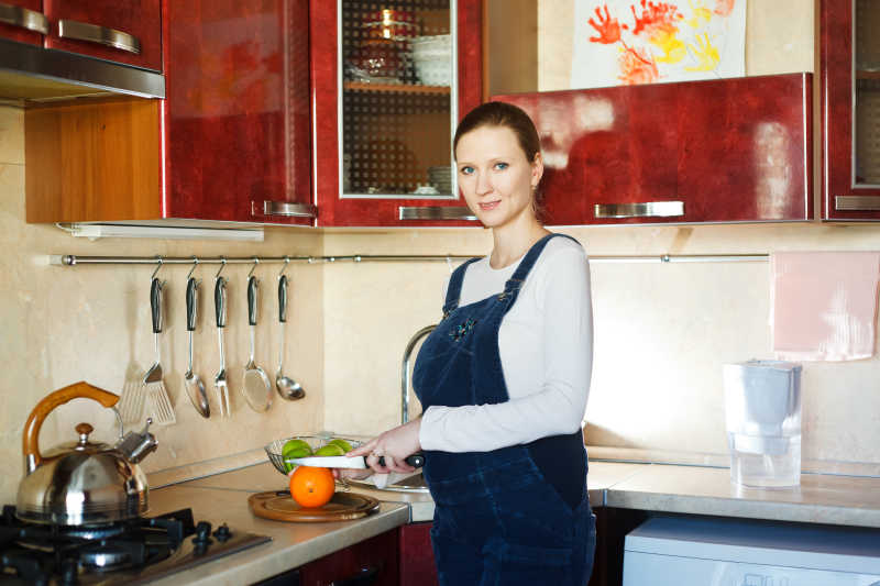 厨房里准备切橙子吃的孕妇