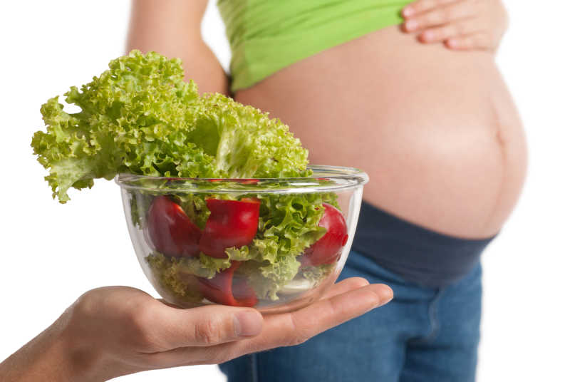 吃健康蔬菜吸取营养的孕妇