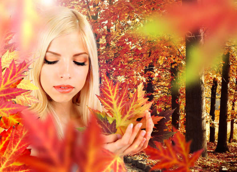 美女在秋季的红枫叶林中