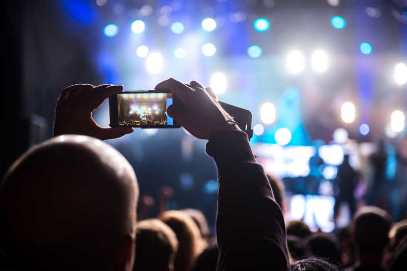 男人用手机捕捉音乐会精彩瞬间