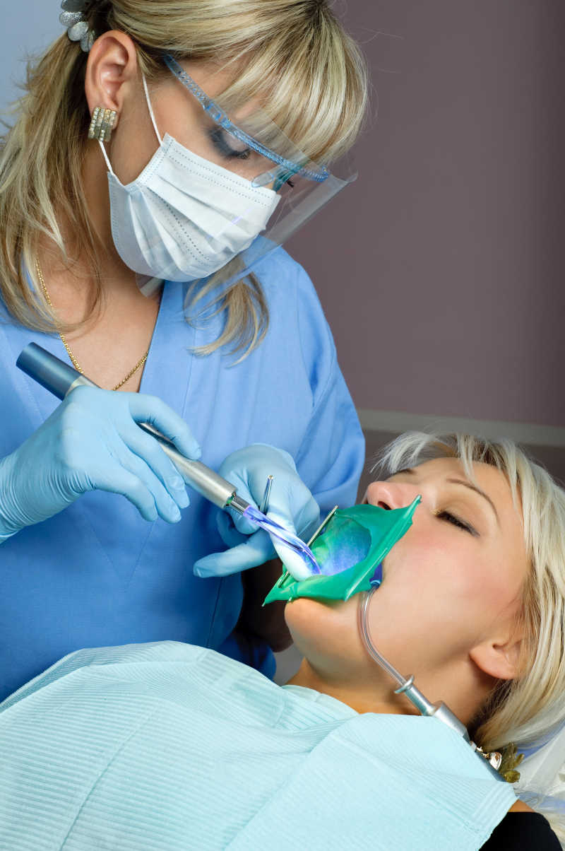 牙科女医生为病人检查牙齿