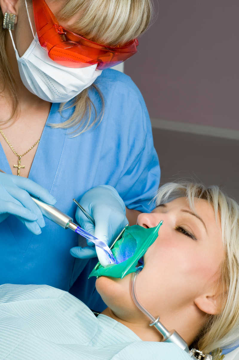 牙医用紫外线为病人检查牙齿
