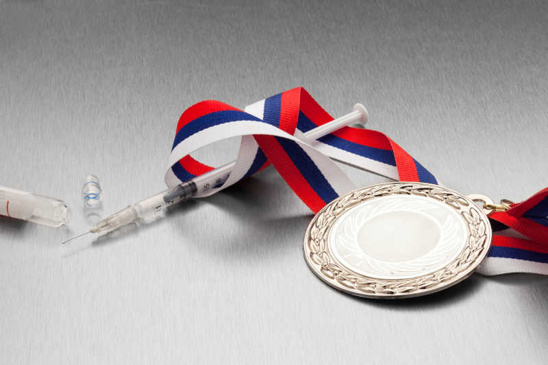 灰色背景上的注射器和金质奖章