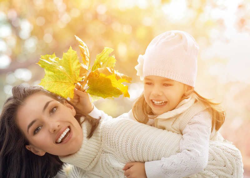 秋季户外母亲背着女儿