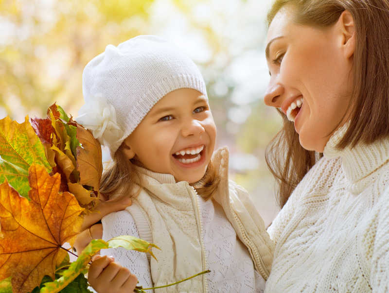 秋季户外拿着树叶的母女