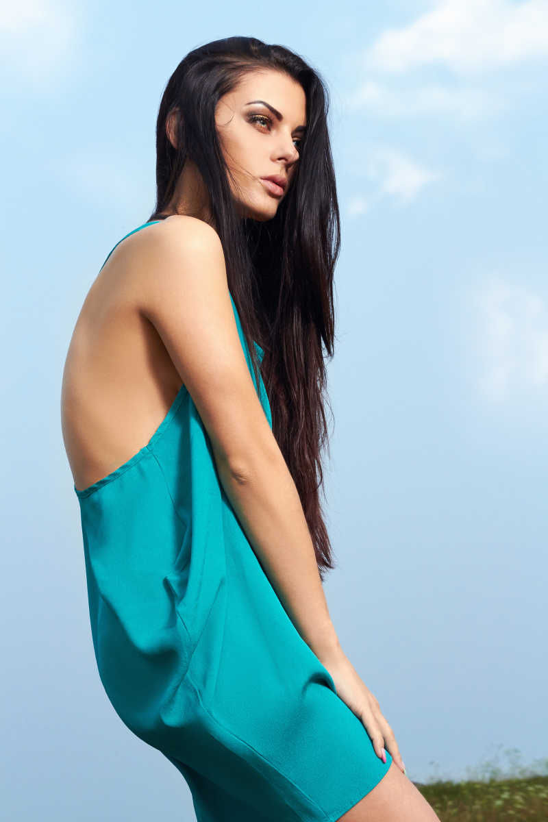 在户外穿着蓝色裙子的黑发美女