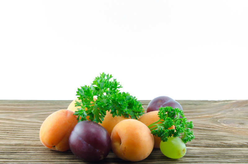 木桌上多汁的葡萄杏李子