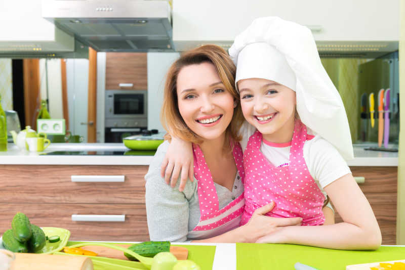 小女孩和母亲在厨房搂着拍照