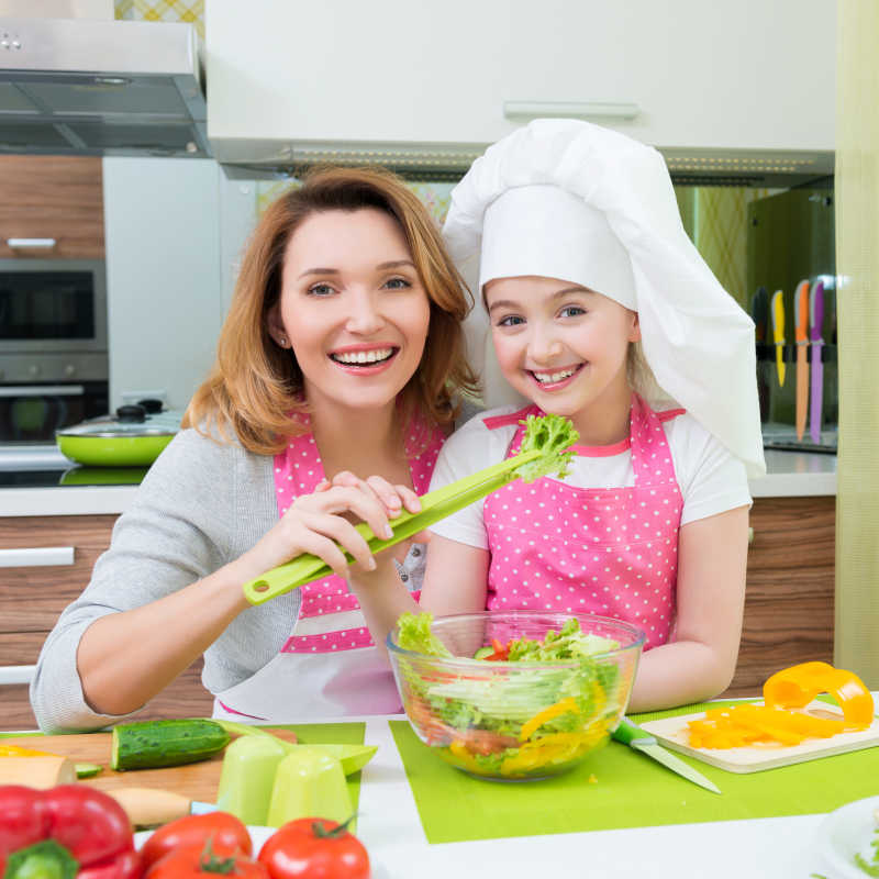 小女孩和母亲在厨房做沙拉