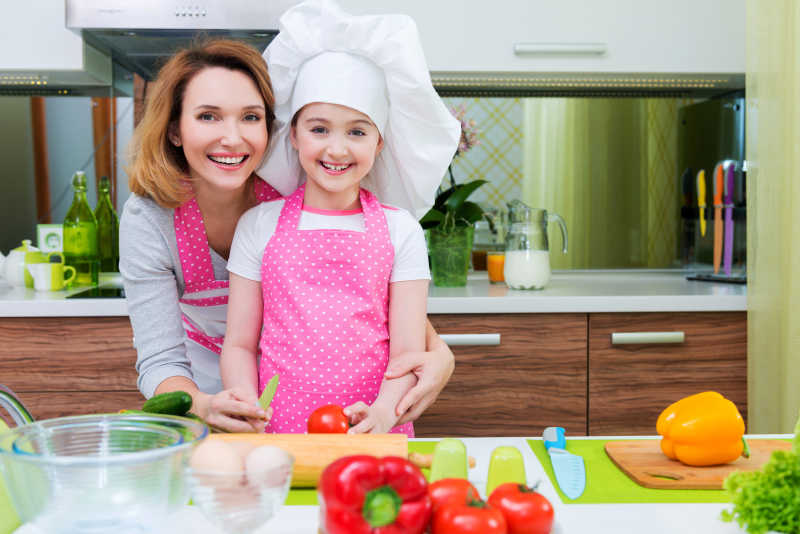 小女孩和母亲在厨房做蔬菜沙拉