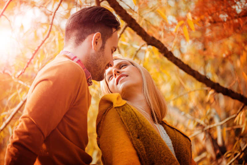 年轻情侣在秋天公园里恋爱